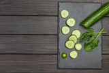 Sliced green cucumber on black cutting board