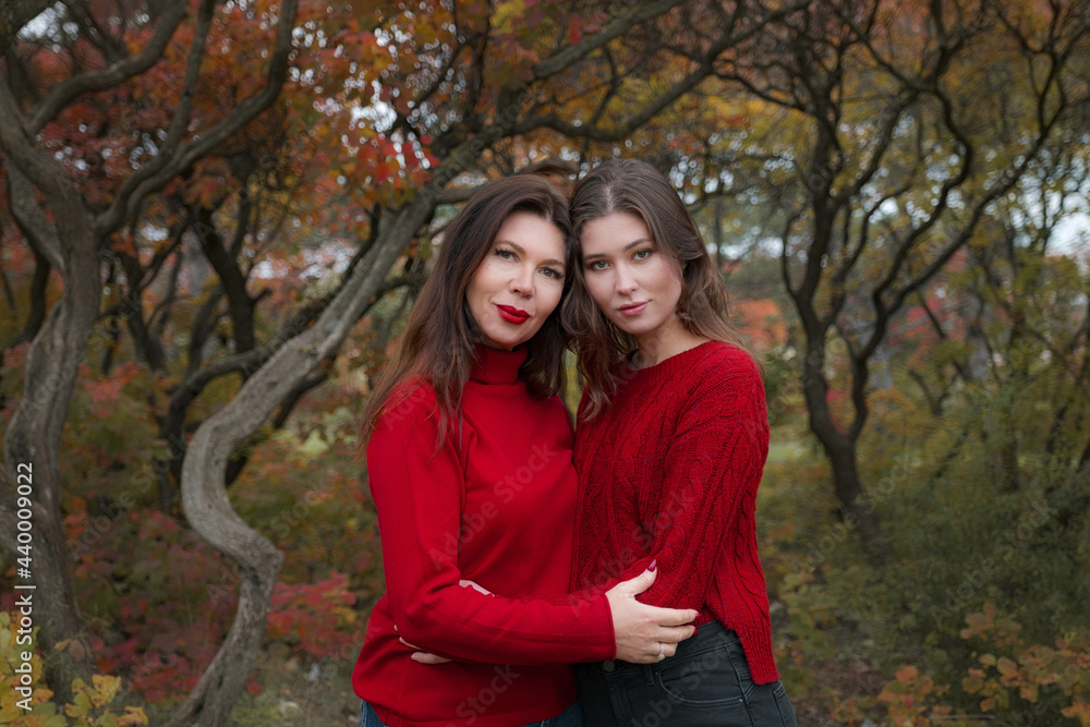 Mature mother hugging with her teen daughter outdoor in nature Mature mother hugging with her teen daughter outdoor in nature