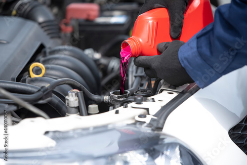 Close up filling coolant in car radiator to reduce the heat of the radiator