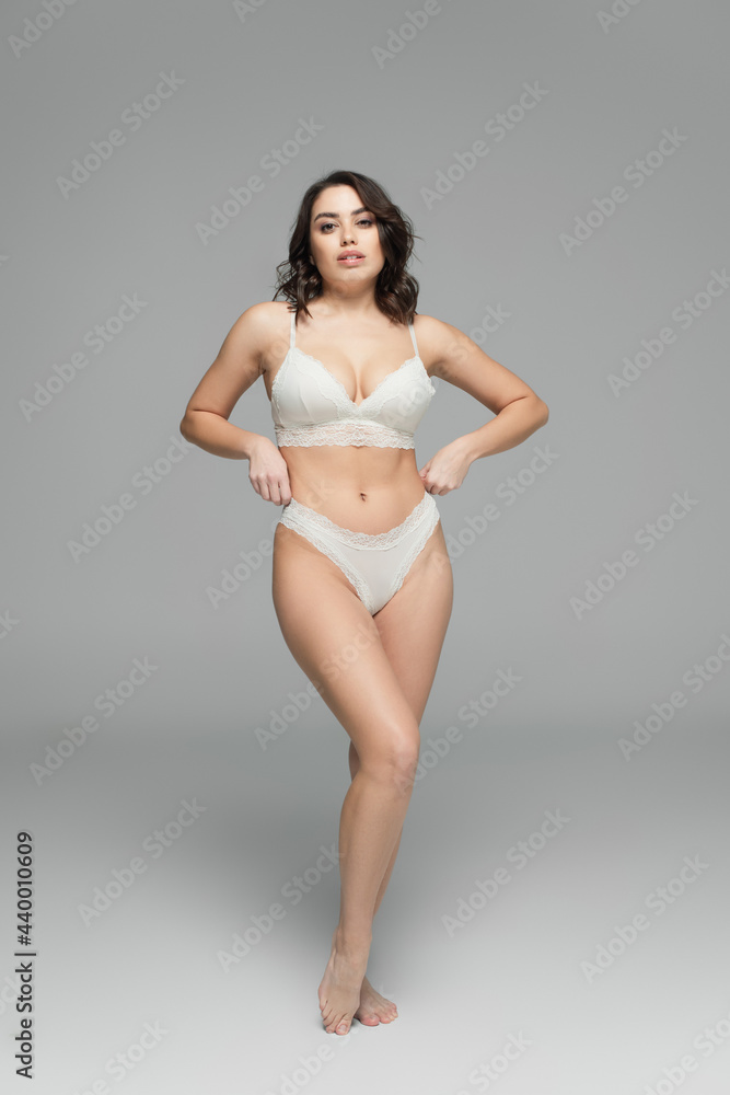 Gorgeous woman in lingerie looking at camera on grey background Gorgeous woman in lingerie looking at camera on grey background