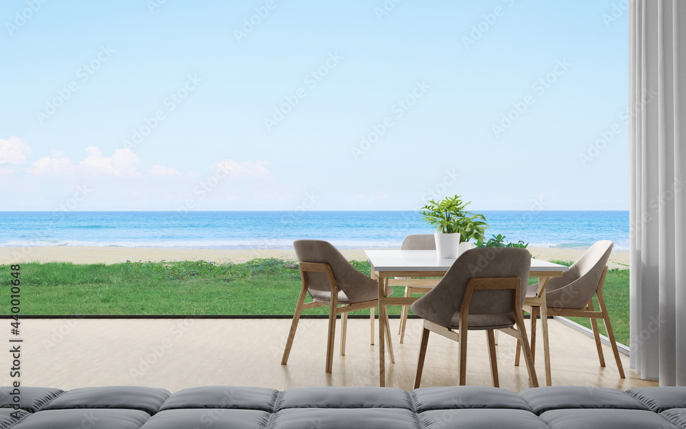 Dining table with chair set and sofa on wooden floor of dining room near living area in modern house or luxury hotel. Minimal home interior 3d rendering with sky and sea view.