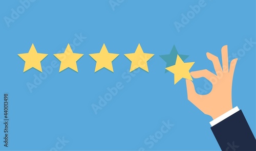 Hand putting five gold stars on blue background. Five stars quality rating icon.