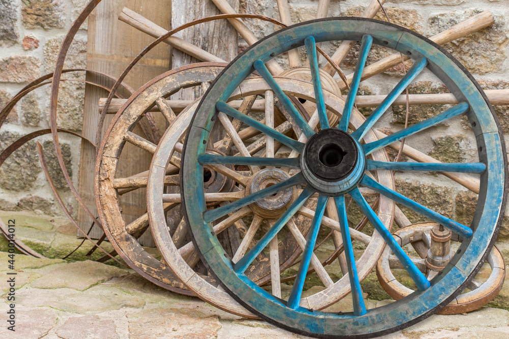 Vieilles roues en bois de véhicules agricoles dans une cour de ferme