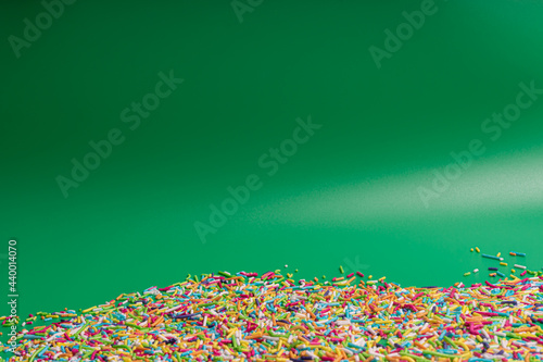 Rainbow Colored Sprinkles on Green Background