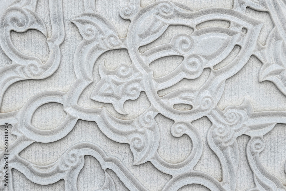 Stone marble wall with carved floral pattern in oriental style