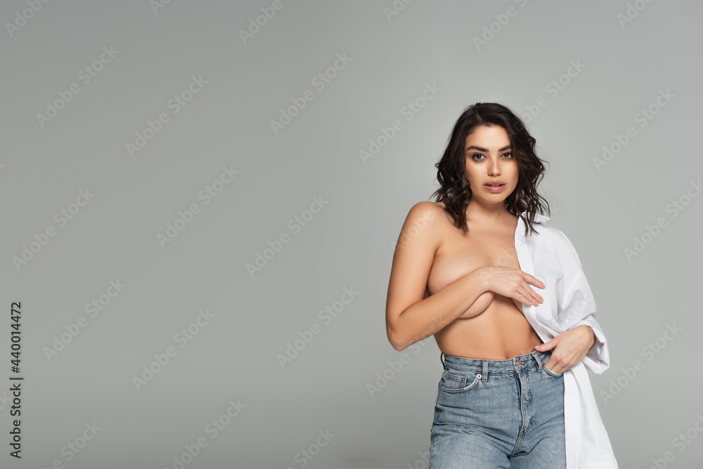 Sensual woman with naked bust posing isolated on grey Sensual woman with naked bust posing isolated on grey