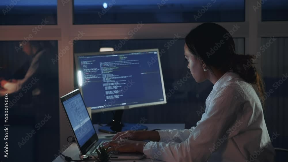 Side view of african american female engineer working on computer in electronics laboratory. Doing Development of Software and Hardware. She wearing a lab coat Side view of african american female engineer working on computer in electronics laboratory. Doing Development of Software and Hardware. She wearing a lab coat