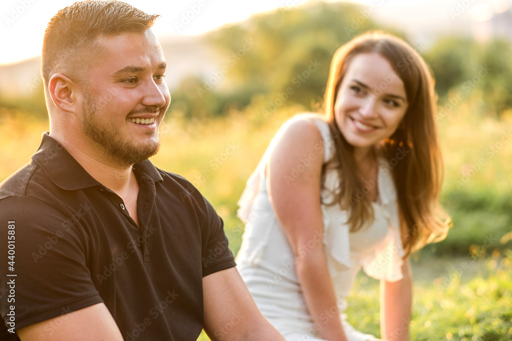 Couple lovers hugging and kissing in park under sunset sky. Love, youth, happiness concept. Summer day Couple lovers hugging and kissing in park under sunset sky. Love, youth, happiness concept. Summer day