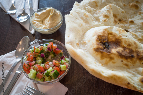 Malmo, Sweden A restaurant table with middle eastern bread, hummus and salad. photo