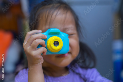 taking pictures of others. Little girl taking picture using toy camera, Photography courses. Camera in hand