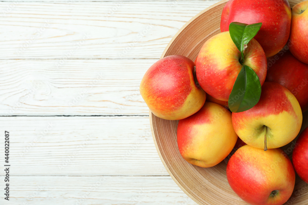 Bowl with red apples on white wooden table Bowl with red apples on white wooden table