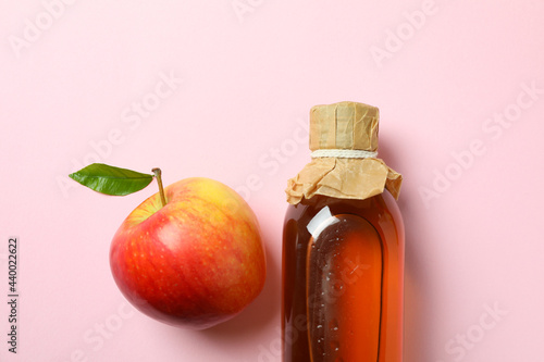 Homemade apple vinegar and ingredient on pink background