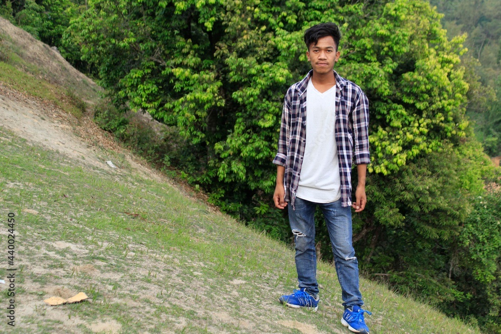 A handsome Nepali young man is standing in front of jungle at Nepal A handsome Nepali young man is standing in front of jungle at Nepal