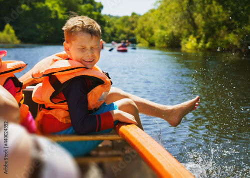 Fotografia Fun in the water in summer - a boy splashes water on the canoe