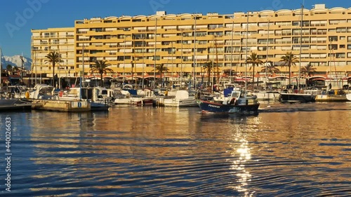 Saint Cyrien, Pyrenees Orientales, France.  The fishing harbour and traditional mediterranean fishing boats in front of flats at Saint Cyprien. Founded in 1960 photo