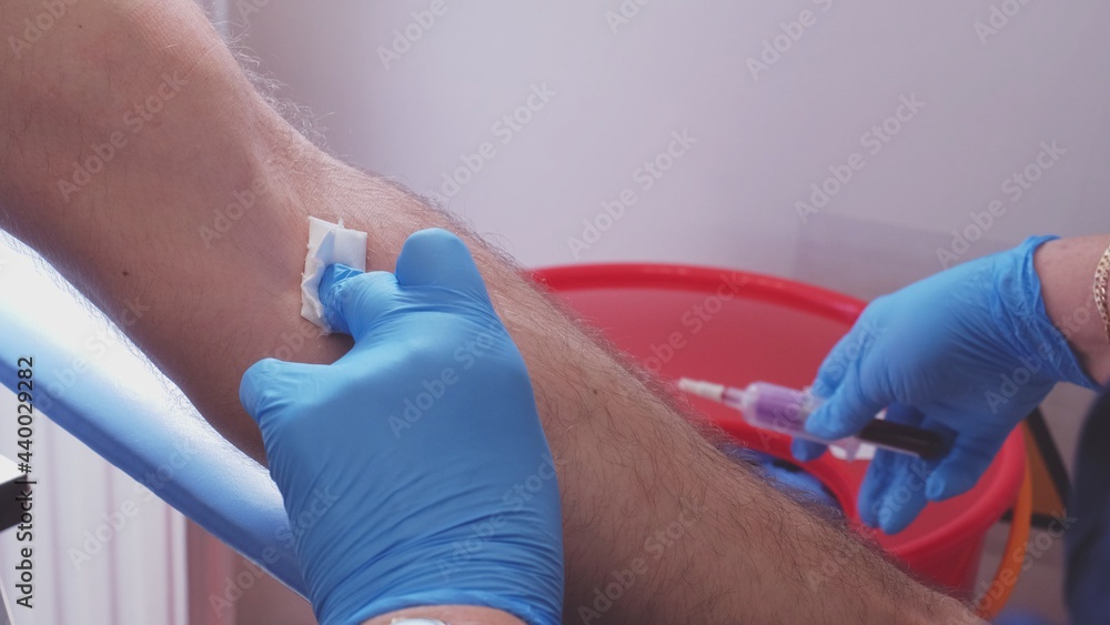 Skilled Professional Nurse in Blue Latex Gloves Collecting Blood Sample