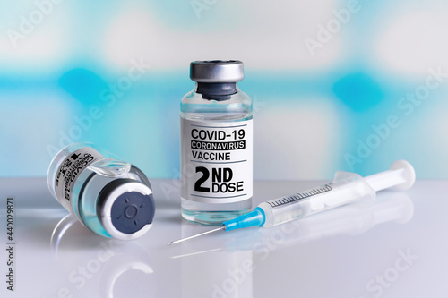 Vaccine bottles identified with first and second dose labels for covid-19 immunization. Two COVID-19 Vaccine Vials tagged with 1st and 2nd dose for vaccination of patients photo