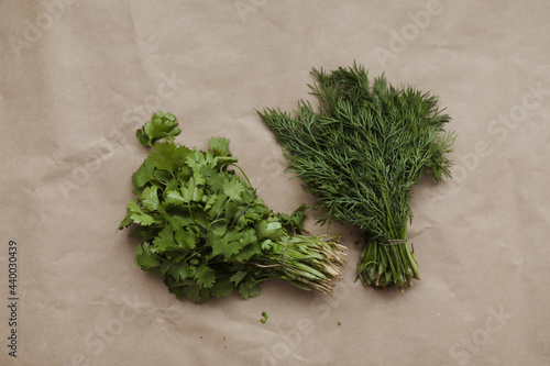 Bunches of fresh greens and organic herbs on beige background. Healthy food. Flat lay, top view, copy space