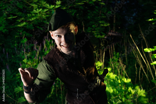 A large portrait of cosplay on Peter Pan against the backdrop of the woods at night