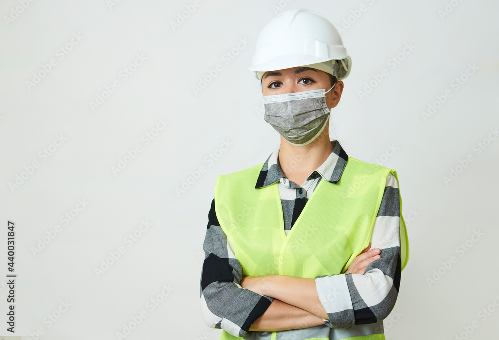 Worker woman wearing face mask and protective hard hat. Worker woman wearing face mask and protective hard hat.