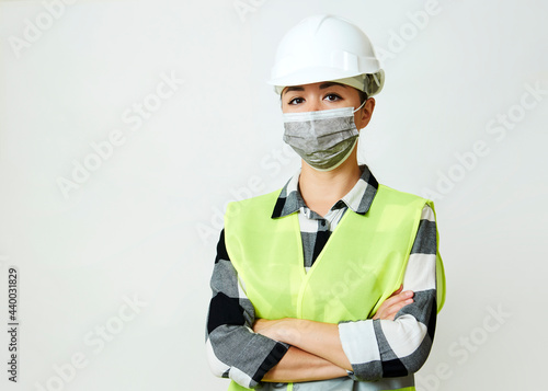 Worker woman wearing face mask and protective hard hat. © Gecko Studio