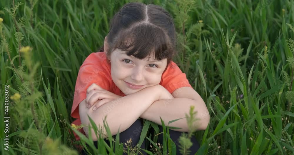 Child calm leisure in the grass. A happy child enjoy the time in the green grass in summer. Child calm leisure in the grass. A happy child enjoy the time in the green grass in summer.
