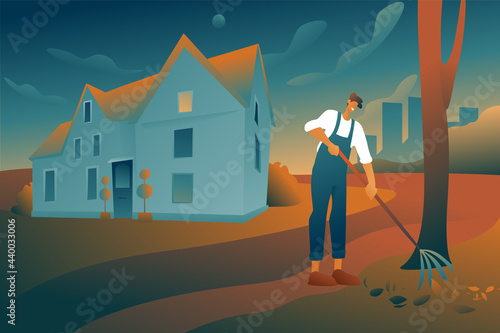 A man removes leaves with a rake on the background of a country house, early in the morning, clearing the territory. The guy is a gardener in overalls with a fan rake. 