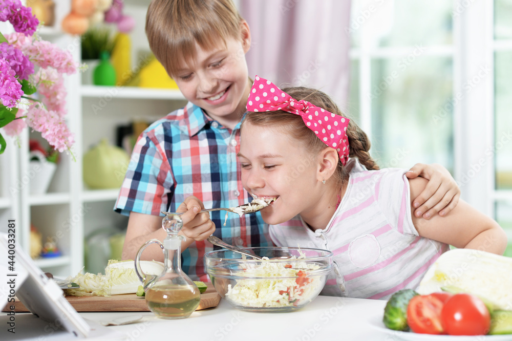 Cute brother and sister cooking together in kitchen Cute brother and sister cooking together in kitchen