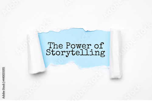 Concept of discovering THE POWER OF STORYTELLING tricks. Uncovered unrolled beige torn paper and search engine optimization abbreviation.