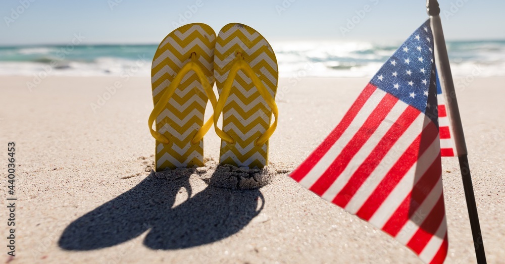 Composition of american flag and flip flops on beach