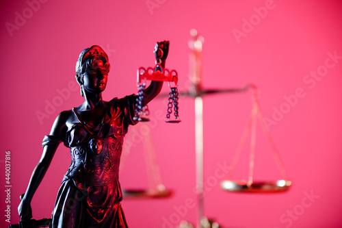 Statue of Lady Justice in red neon. Symbol of justice and law. Close-up