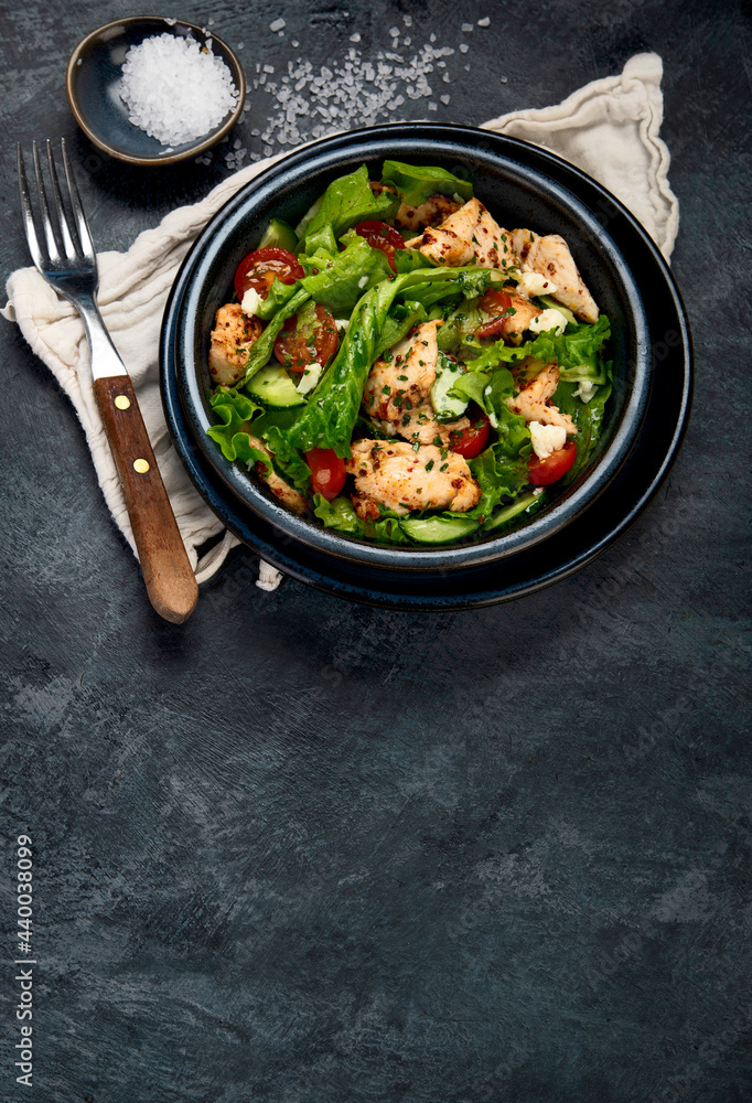 Fresh chicken salad on drak gray background. Healthy food concept.