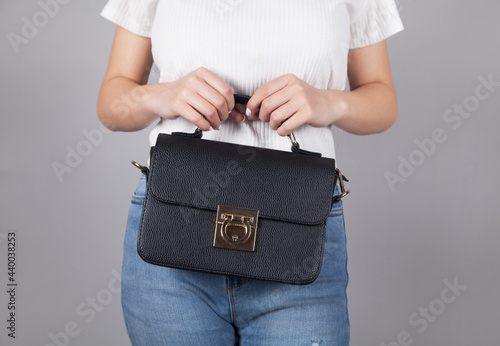  Woman holding stylish female handbag.