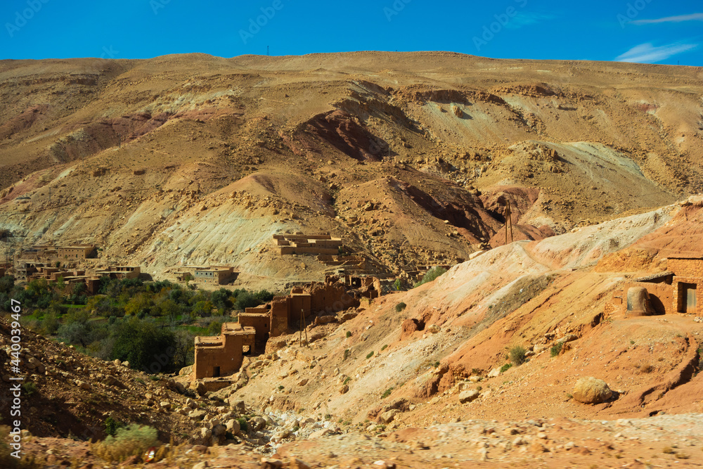 mud-brick village and bare hill side in the High Atlas mountains with a clear blue sky