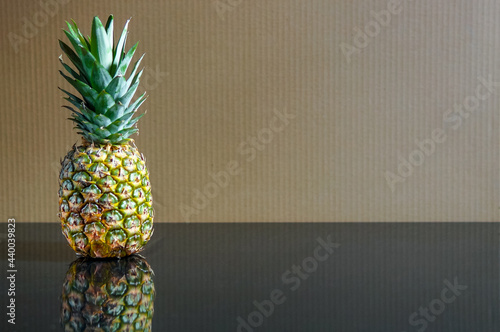 Fresh pineapple over brown wall background