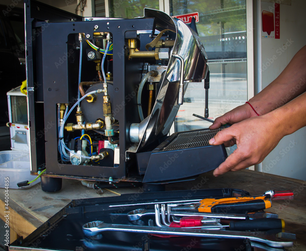 A man fixing coffee machine,repairing broken coffee machin. A man fixing coffee machine,repairing broken coffee machin.