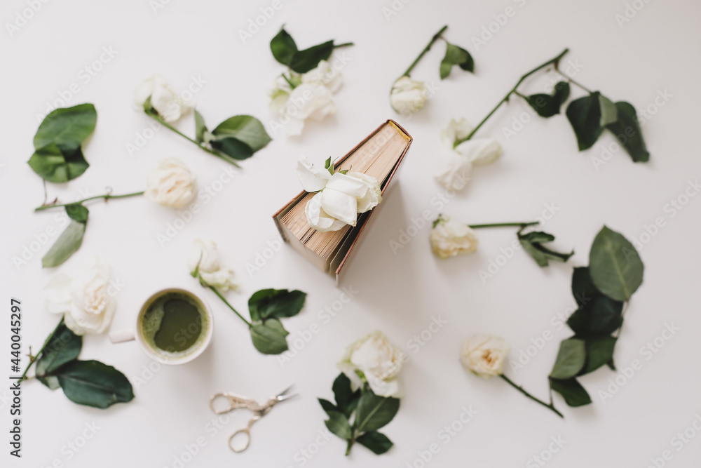 Beautiful romantic composition with cup of matcha green tea and rose flowers on white background. Flatlay, top view Beautiful romantic composition with cup of matcha green tea and rose flowers on white background. Flatlay, top view