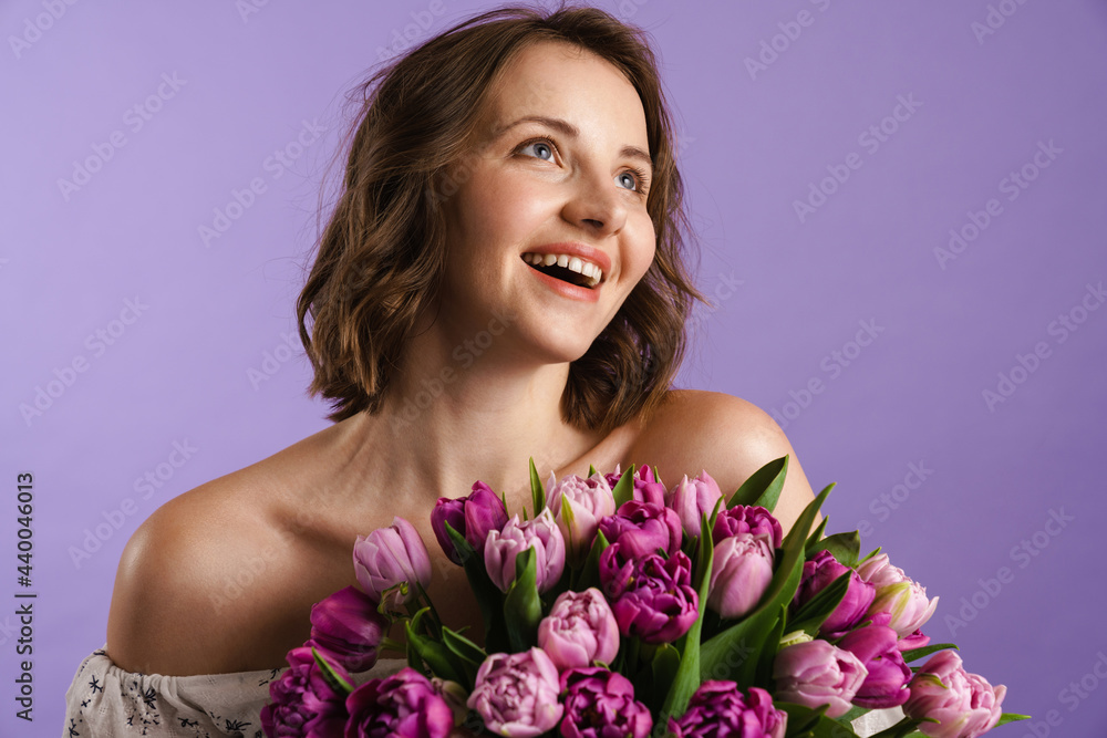 White young woman smiling while posing with tulips