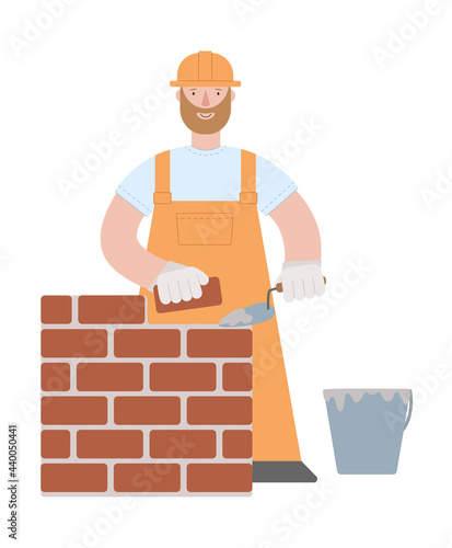 a bricklayer builder in orange uniform and hard hat building a brick wall