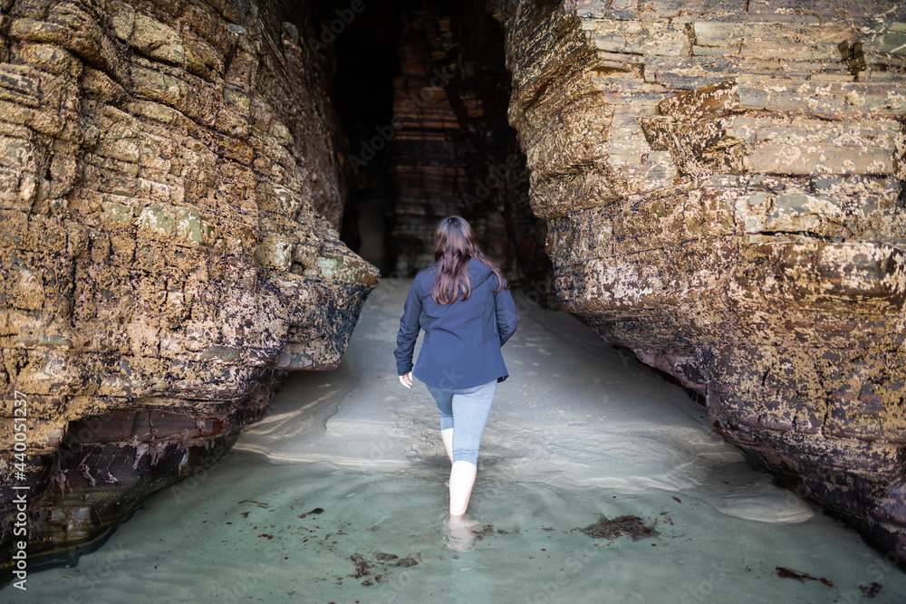 Woman walking in the water in a cave at the beach, lifestyle, copy space. Woman walking in the water in a cave at the beach, lifestyle, copy space.