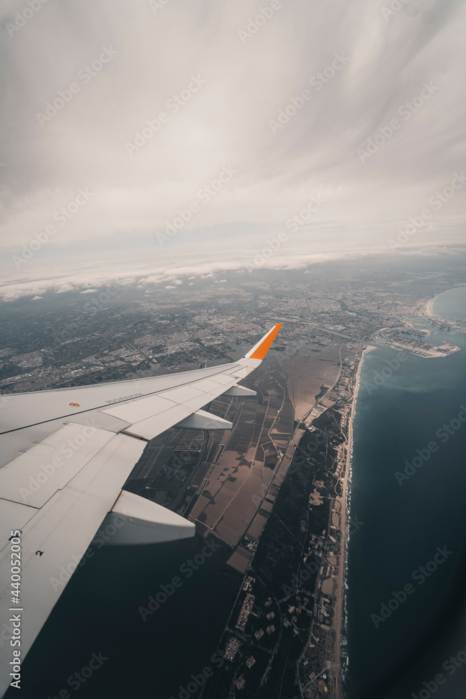 Fototapeta premium Vista de pajaro desde la ventana de un avion desde donde se ven las nubes en un mar de nubes y el ala del avion
