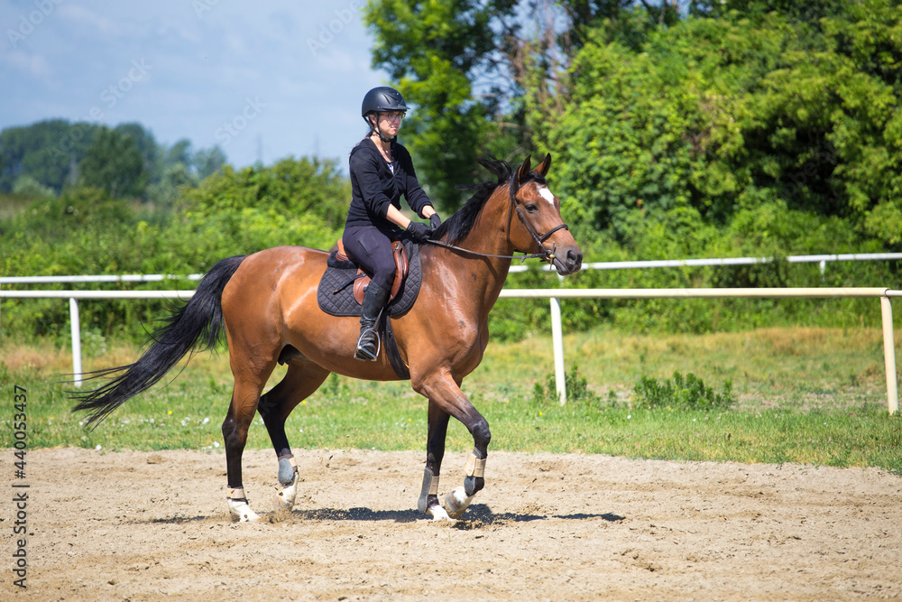 The girl in black rides a sorrel horse in nature The girl in black rides a sorrel horse in nature