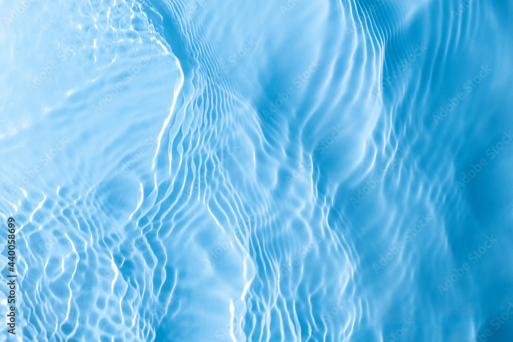 Surface of cosmetic moisturizer splash reflections on scattered sun. light blue of sea abstract background