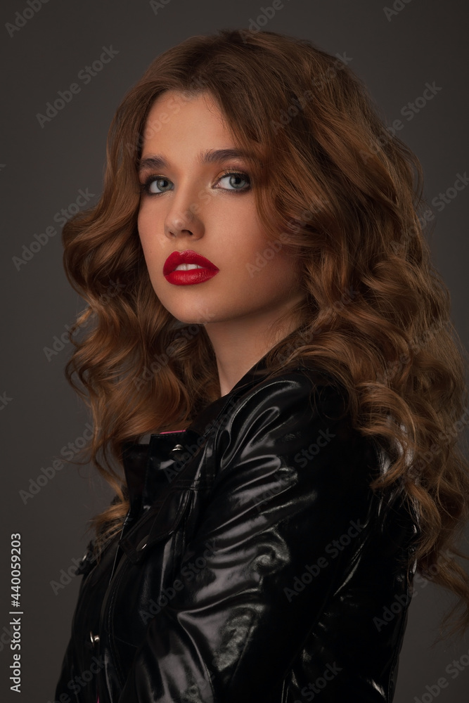 portrait of a beautiful girl with bright makeup and hairstyle in a black leather jacket
