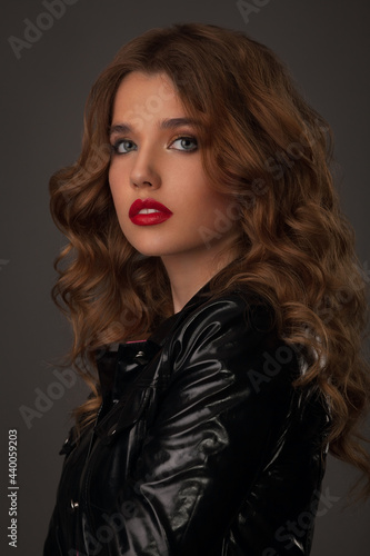 portrait of a beautiful girl with bright makeup and hairstyle in a black leather jacket