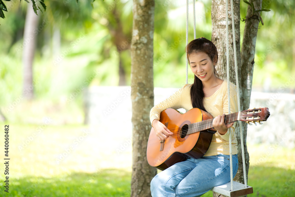 Woman people playing guitar in morning relax at nature garden home. Asia female beauty and smiling chill and enjoy in summer holiday