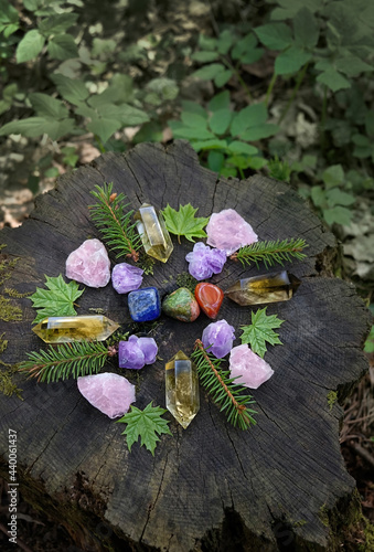 colorful mineral gemstones and leaves on natural forest background. Magic quartz stones for Crystal Ritual, Esoteric spiritual practice. wicca altar. top view