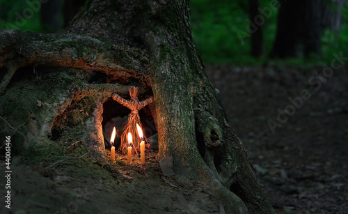 Fotografija witchcraft doll and candles on natural forest dark background