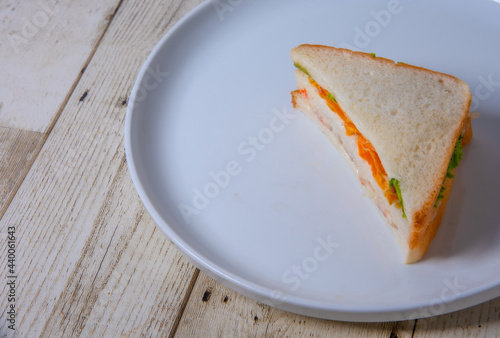 Sandwiches in white plates on wooden floor