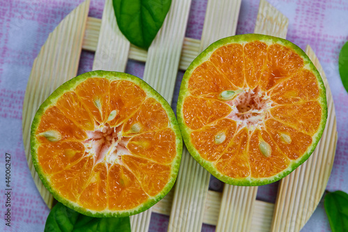 closeup cut of half tangerine isolated on the wooden plate